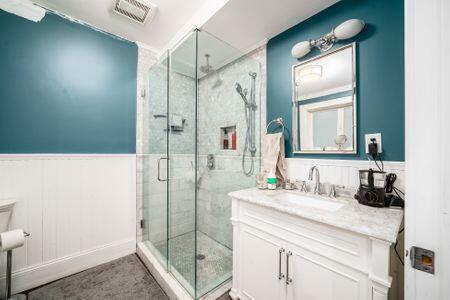 1349 E Broad St, Columbus, OH 43205 - full bath featuring a stall shower, wainscoting, visible vents, and vanity