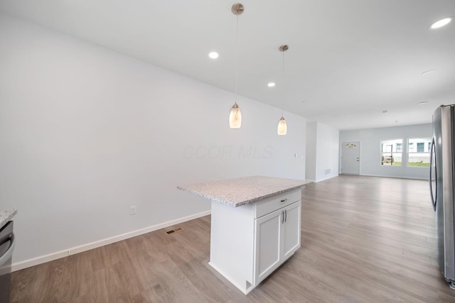 1559 Obetz Ave, Obetz, OH 43207 - kitchen featuring open floor plan, baseboards, hanging light fixtures, light wood finished floors, and freestanding refrigerator