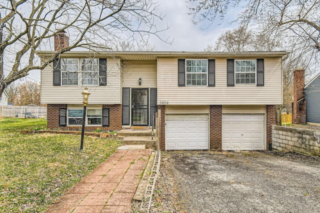 3484 Sweetday St, Columbus, OH 43224 - bi-level home with brick siding, an attached garage, a chimney, asphalt driveway, and fence