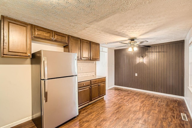 3484 Sweetday St, Columbus, OH 43224 - kitchen featuring freestanding refrigerator, a ceiling fan, baseboards, dark wood-style floors, and wood walls