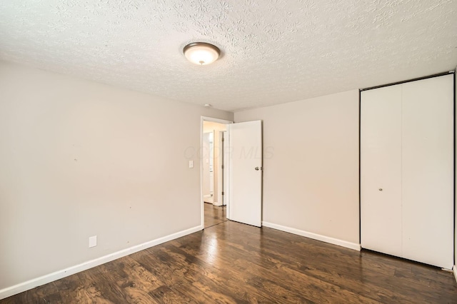 3484 Sweetday St, Columbus, OH 43224 - unfurnished bedroom featuring wood finished floors, baseboards, a closet, and a textured ceiling