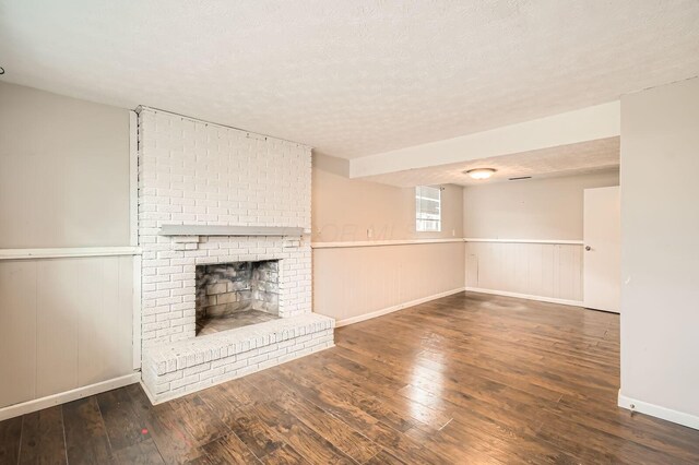 3484 Sweetday St, Columbus, OH 43224 - unfurnished living room with hardwood / wood-style flooring, wainscoting, a brick fireplace, a textured ceiling, and baseboards