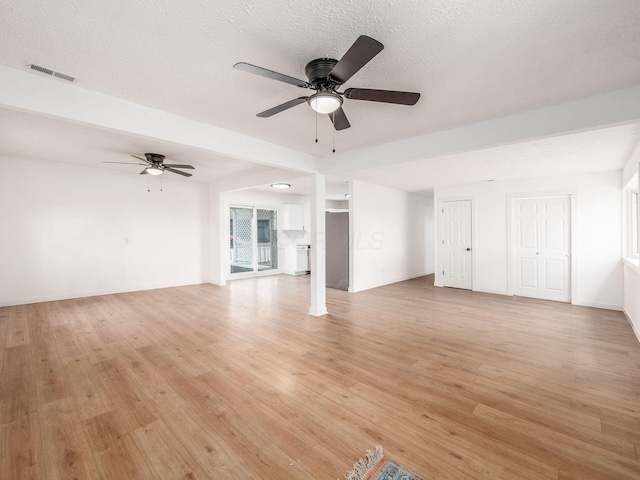 unfurnished living room featuring visible vents, light wood-style flooring, and ceiling fan
