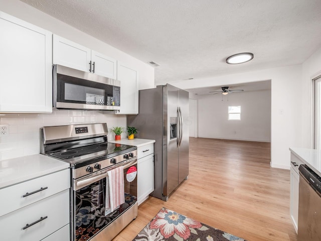 kitchen with light wood-style floors, light countertops, ceiling fan, and appliances with stainless steel finishes