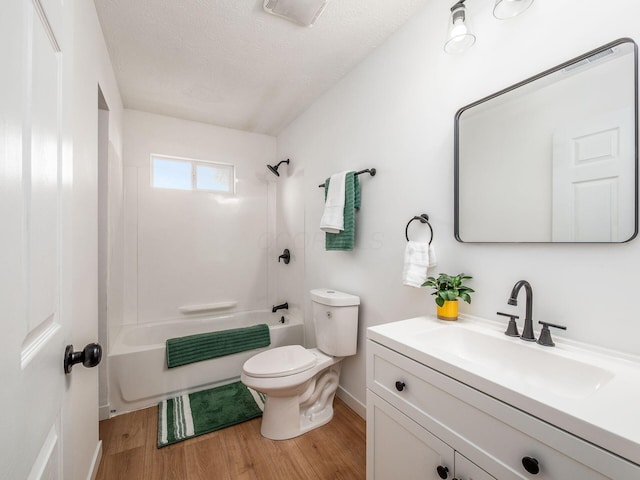 full bath featuring toilet, vanity,  shower combination, wood finished floors, and a textured ceiling