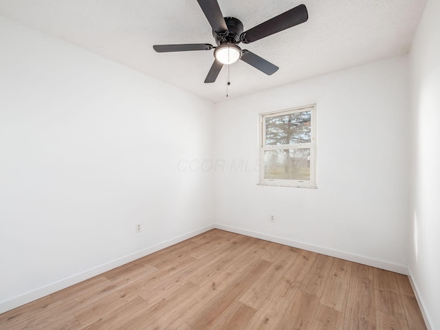 spare room featuring baseboards, a textured ceiling, ceiling fan, and light wood-style floors