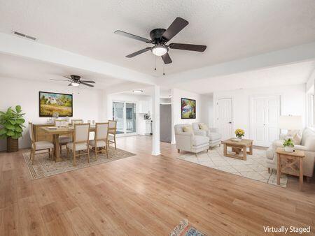 living area featuring a ceiling fan, visible vents, and light wood-type flooring