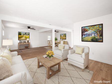 living area featuring light wood-style flooring and a ceiling fan