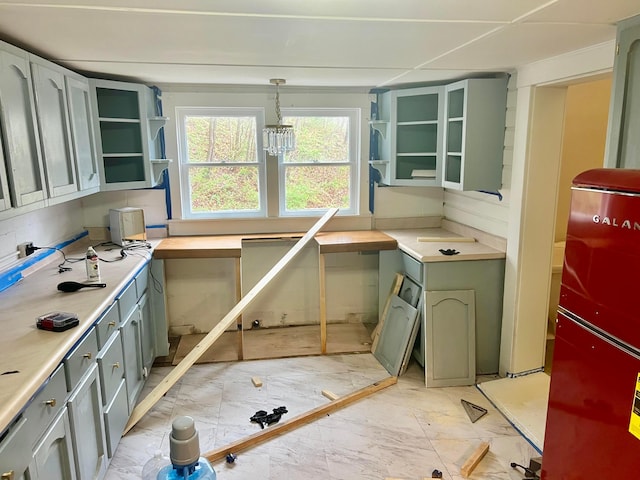 kitchen with pendant lighting, marble finish floor, light countertops, and open shelves