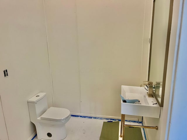 half bath featuring toilet and a sink