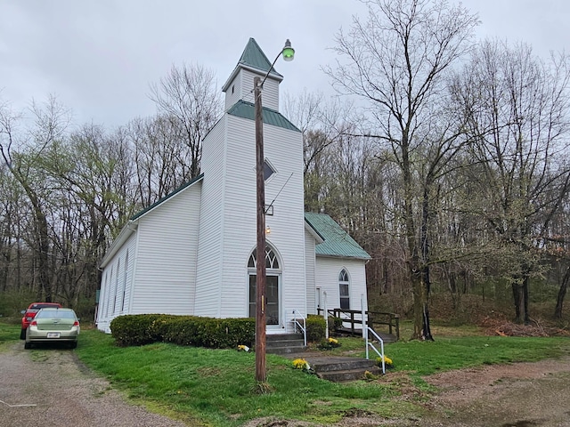 view of front facade featuring a front lawn and metal roof