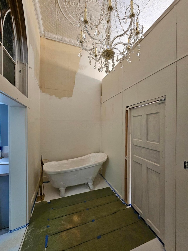 bathroom with an inviting chandelier and a soaking tub