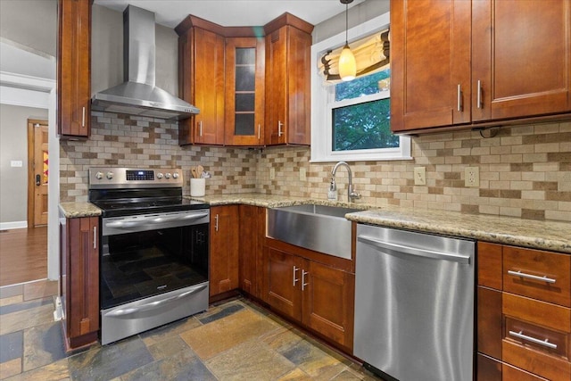 kitchen with wall chimney range hood, backsplash, appliances with stainless steel finishes, light stone countertops, and a sink