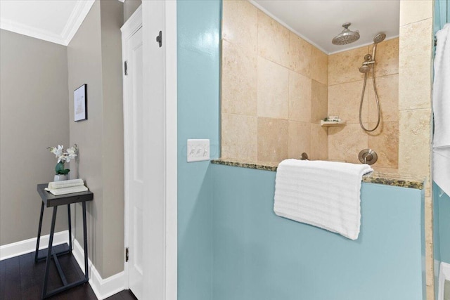 full bath with baseboards, ornamental molding, and a tile shower