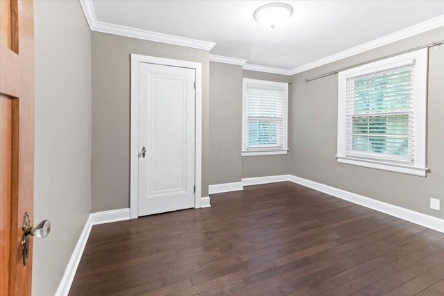 unfurnished bedroom featuring crown molding, baseboards, and dark wood-style floors