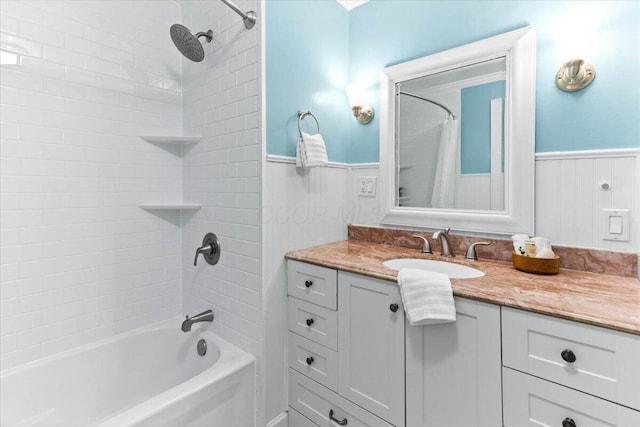 full bathroom featuring vanity, wainscoting, and shower / tub combo