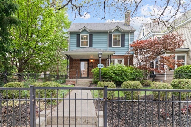 view of front of property with brick siding, a fenced front yard, a gate, and a chimney