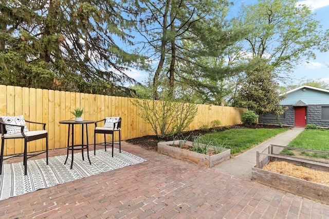 view of patio with a fenced backyard and a garden