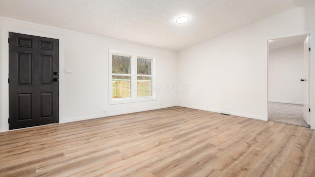 empty room with baseboards and light wood finished floors