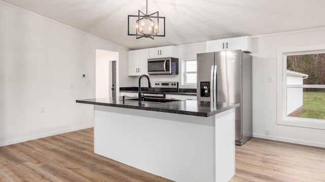 kitchen with vaulted ceiling, a sink, stainless steel appliances, dark countertops, and an inviting chandelier