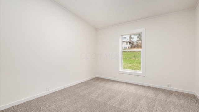 empty room featuring light colored carpet, baseboards, and ornamental molding