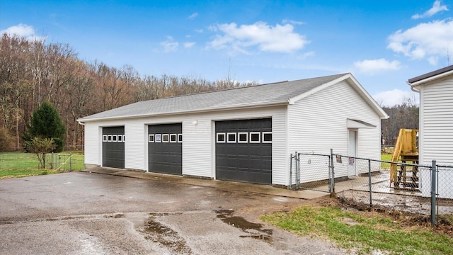 detached garage featuring a gate and fence