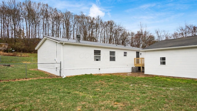 back of property featuring cooling unit, fence, a yard, and metal roof