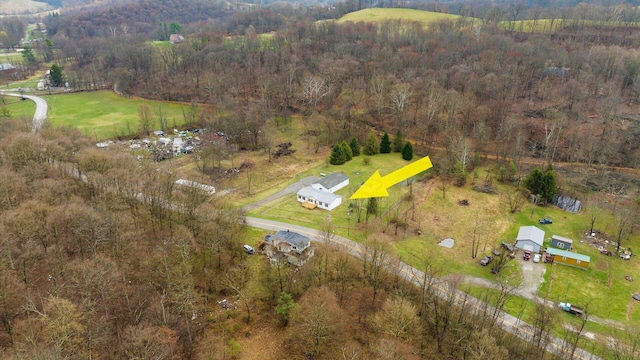 drone / aerial view featuring a wooded view