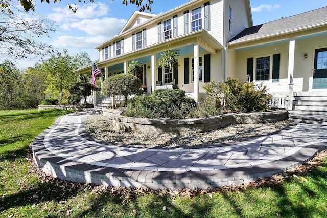 view of front facade with a front yard and covered porch