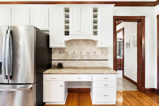 kitchen with white cabinetry, decorative backsplash, and stainless steel refrigerator with ice dispenser