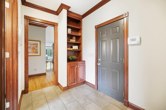 foyer with baseboards, ornamental molding, and light tile patterned floors