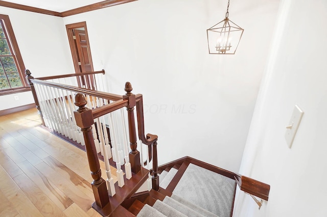 stairs with baseboards, crown molding, wood finished floors, and a chandelier