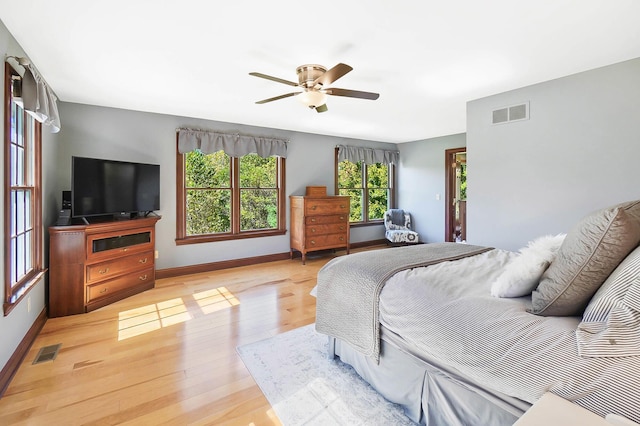bedroom with light wood-style flooring, baseboards, ceiling fan, and visible vents