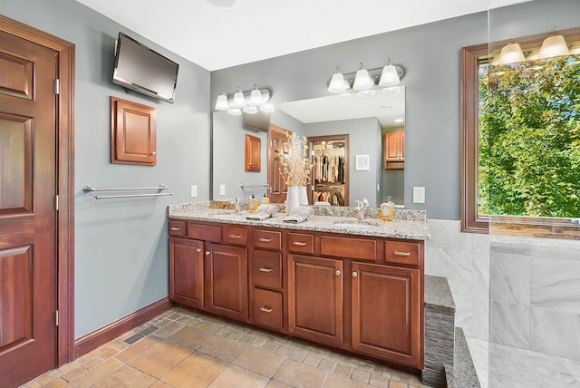 bathroom featuring double vanity, visible vents, baseboards, and a sink