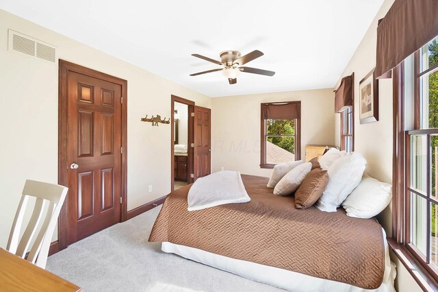 bedroom featuring baseboards, carpet floors, visible vents, a ceiling fan, and ensuite bathroom