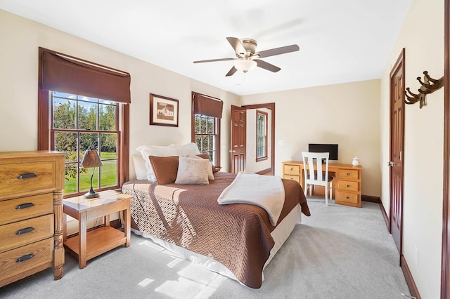 bedroom featuring light colored carpet, ceiling fan, and baseboards