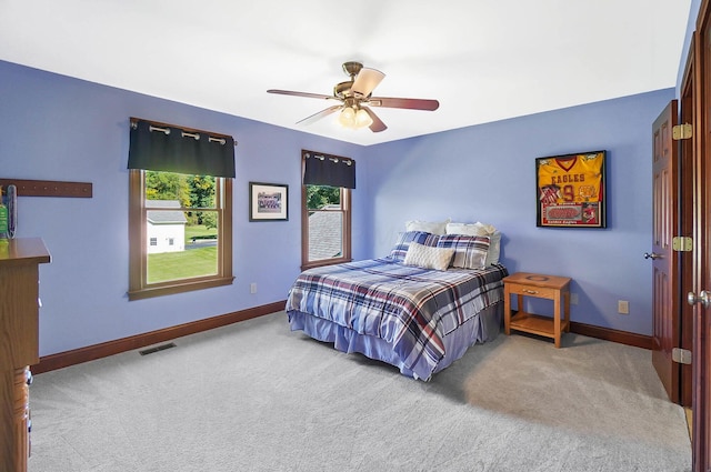 carpeted bedroom featuring baseboards, visible vents, and ceiling fan