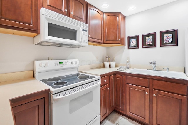 kitchen featuring light countertops, a sink, light tile patterned floors, white appliances, and recessed lighting