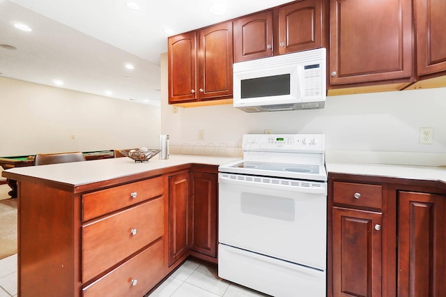 kitchen with light countertops, recessed lighting, white appliances, light tile patterned floors, and a peninsula