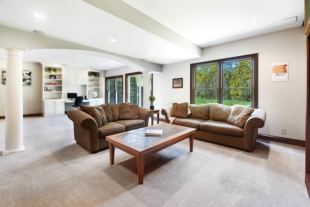 living area featuring decorative columns, light carpet, baseboards, arched walkways, and recessed lighting