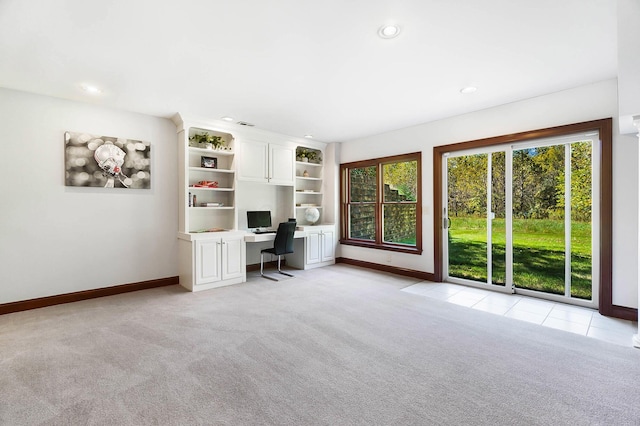 unfurnished office with light carpet, baseboards, and built in study area