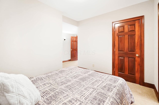 bedroom featuring baseboards and light colored carpet