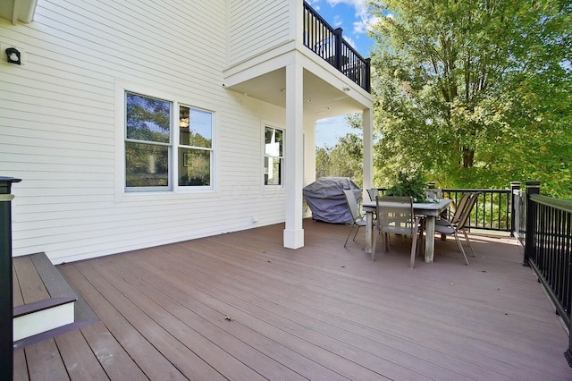 wooden deck featuring a grill and outdoor dining area