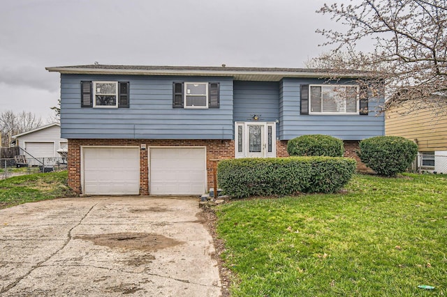 3104 Lewis Rd, Columbus, OH 43207 - bi-level home with a garage, brick siding, a front yard, and concrete driveway