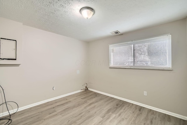 3104 Lewis Rd, Columbus, OH 43207 - spare room featuring wood finished floors, electric panel, and a textured ceiling