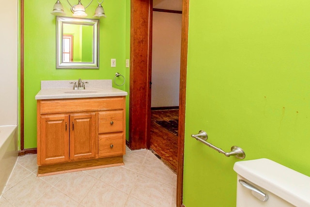 bathroom with toilet, tile patterned floors, and vanity