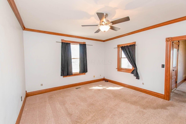 unfurnished room featuring baseboards, crown molding, carpet floors, and a ceiling fan