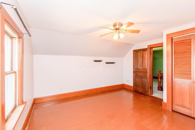bonus room featuring baseboards, lofted ceiling, ceiling fan, and light wood-type flooring