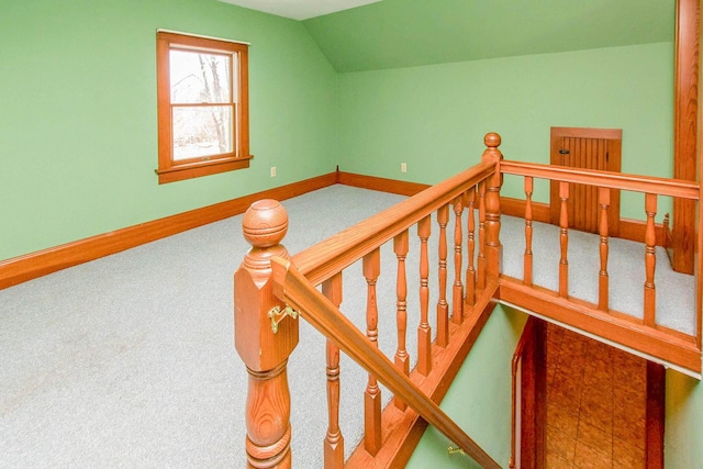 stairway with baseboards, vaulted ceiling, and carpet