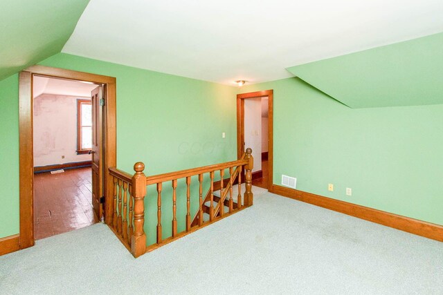 bonus room featuring baseboards, carpet, lofted ceiling, and visible vents